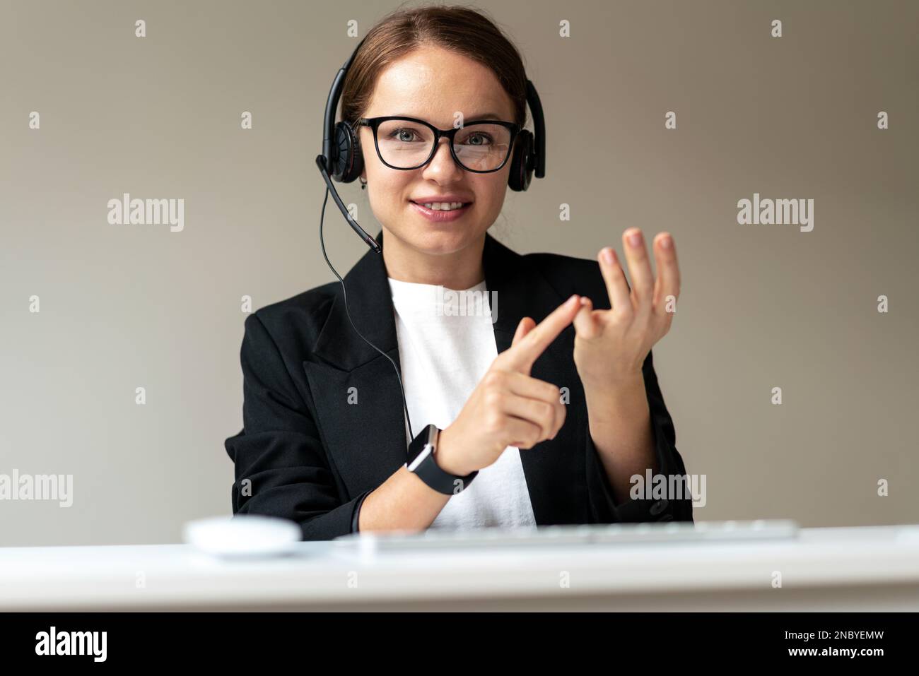 Online-Videoanruf mit persönlichem Entwicklungscoach, Frau mit Brille und Headset, die die Webcam mit den Fingern zählt. Stockfoto