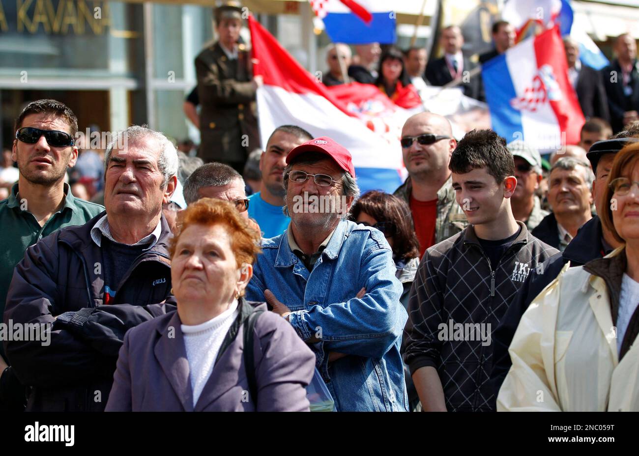 People watch a live broadcast of the verdict from the Yugoslav war crimes tribunal in The Hague at the main square in Zagreb, Croatia, Friday, April 15, 2011. A U.N. court has convicted a key wartime Croatian commander, Gen. Ante Gotovina, of committing atrocities in a campaign of shelling, murder and persecution aimed at driving Serbs out of Croatia's Krajina border region in 1995. (AP Photo/Darko Bandic) Stockfoto