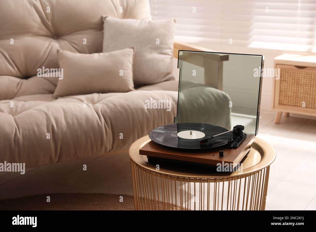 Eleganter Plattenspieler mit Vinylscheibe im Wohnzimmer Stockfoto