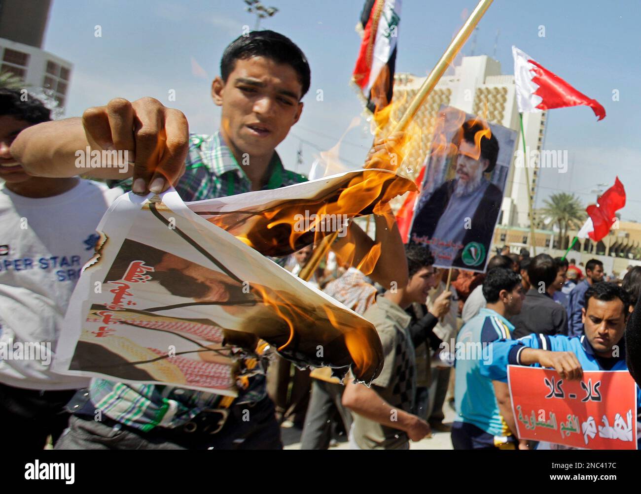 Saudi Anonymous A protester burns posters depicting King Abdullah of Saudi Arabia and ...