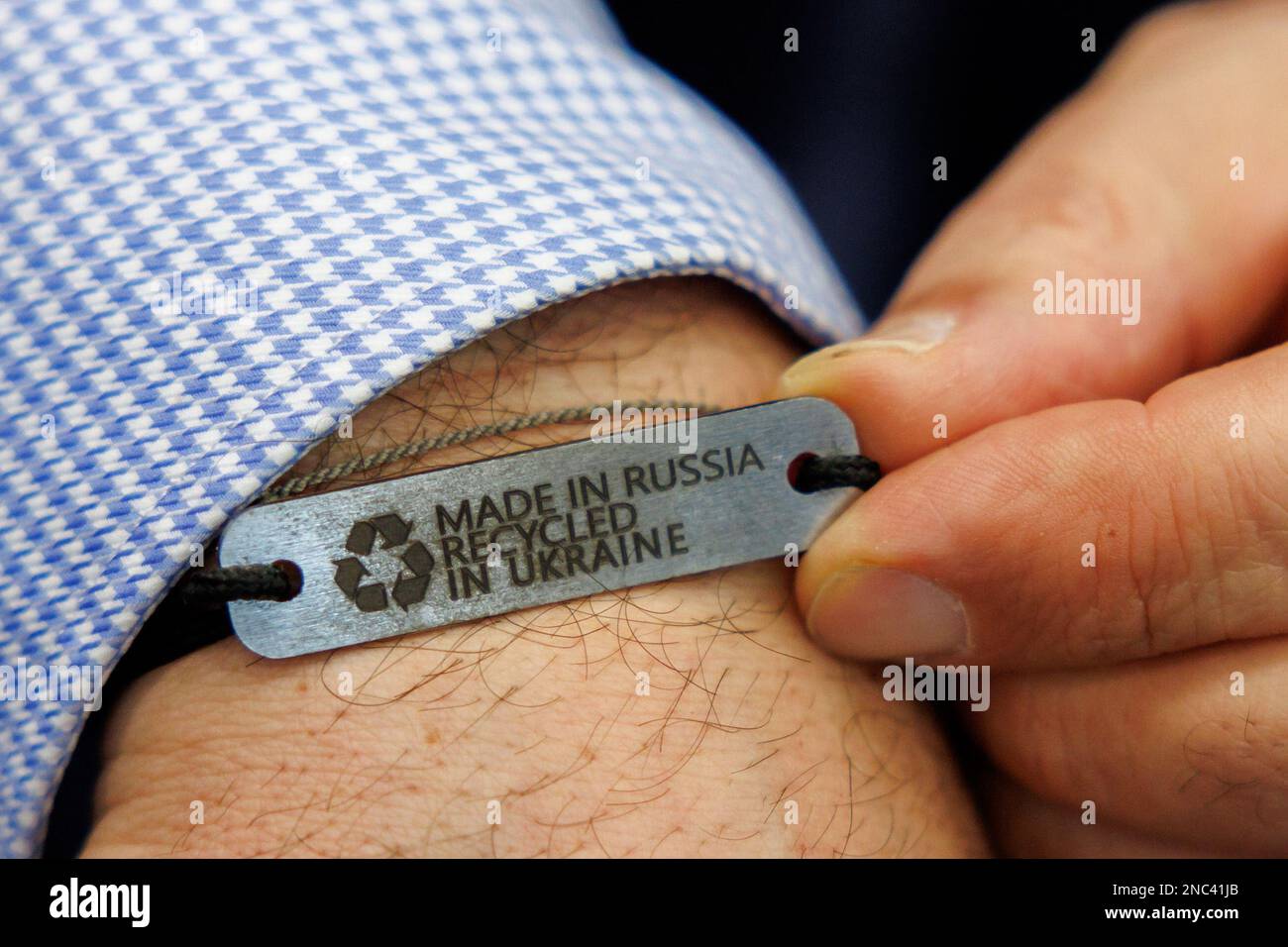 Nürnberg, Deutschland. 14. Februar 2023. Bundesminister für Landwirtschaft Cem Özdemir (M, Bündnis 90/die Grünen) zeigt sein Armband mit der Aufschrift „Made in Russia - Recycled in Ukraine“ auf einer Führung durch die Biofach-Messe im ukrainischen Pavillon. Vom 14. Bis 17. Februar 2023 werden auf der weltweit führenden Fachmesse für Biofach und der Fachmesse für Naturkosmetika VIVANESS 2.765 Aussteller aus 95 Ländern Produkte der Bio-Lebensmittel- und Naturkosmetikindustrie präsentieren. Kredit: Daniel Karmann/dpa/Alamy Live News Stockfoto