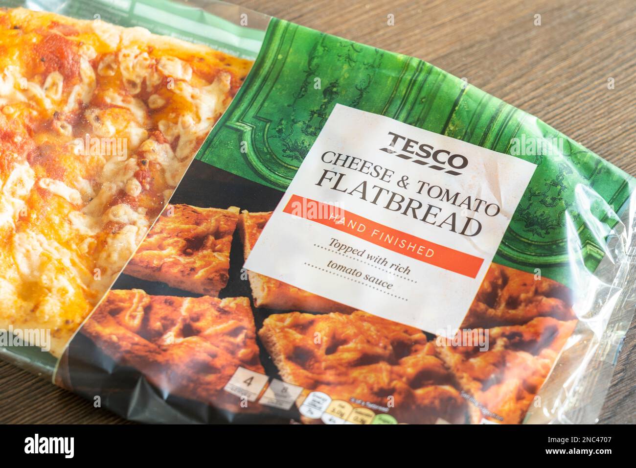 Ein Tesco Supermarkt, handgefertigter Käse und Tomaten-Fladenbrot in Kunststoffverpackung auf einer Küchenarbeitsfläche. UK. Konzept: Lebensmittel der Eigenmarke des Supermarkts Stockfoto