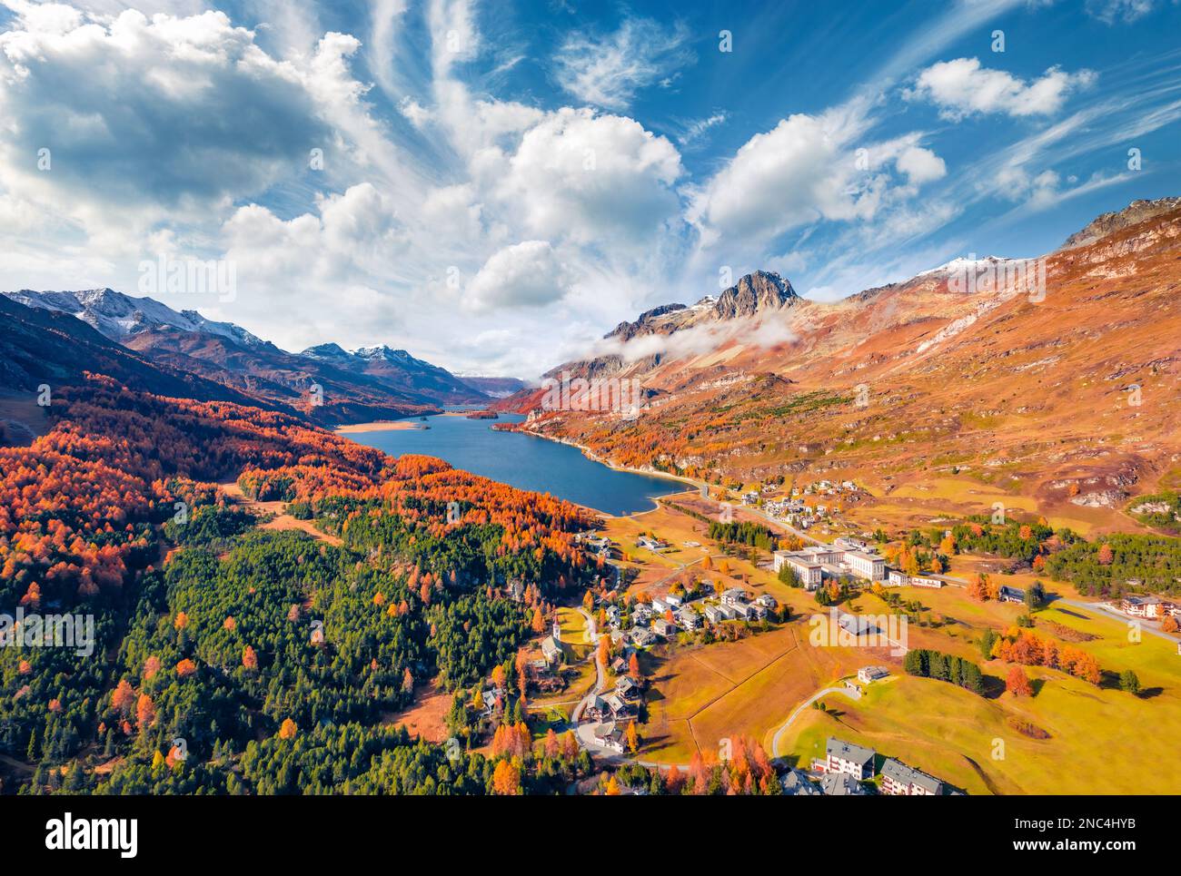 Atemberaubender Herbstblick von der fliegenden Drohne auf den Sils Lake. Spektakuläre Morgenlandschaft der Schweizer Alpen. Luftaufnahme im Dorf Maloya, Switzerla Stockfoto