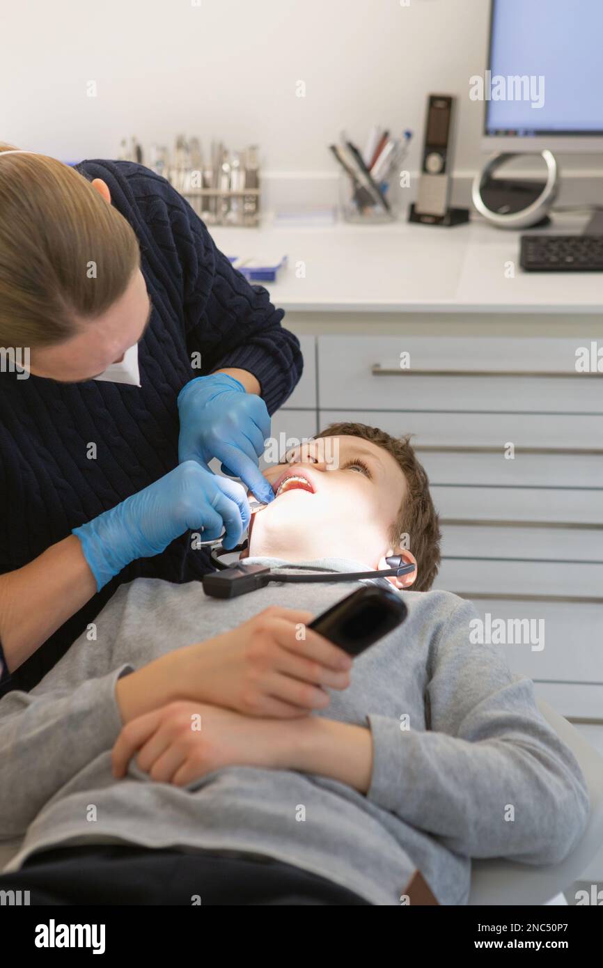 Kind in einer Zahnklinik. Kieferorthopädische Behandlung. Kinderzahnheilkunde, Kinderzahnheilkunde. Ein Junge mit Zahnspange an den Zähnen bei einem Zahnarzttermin. Ora Stockfoto