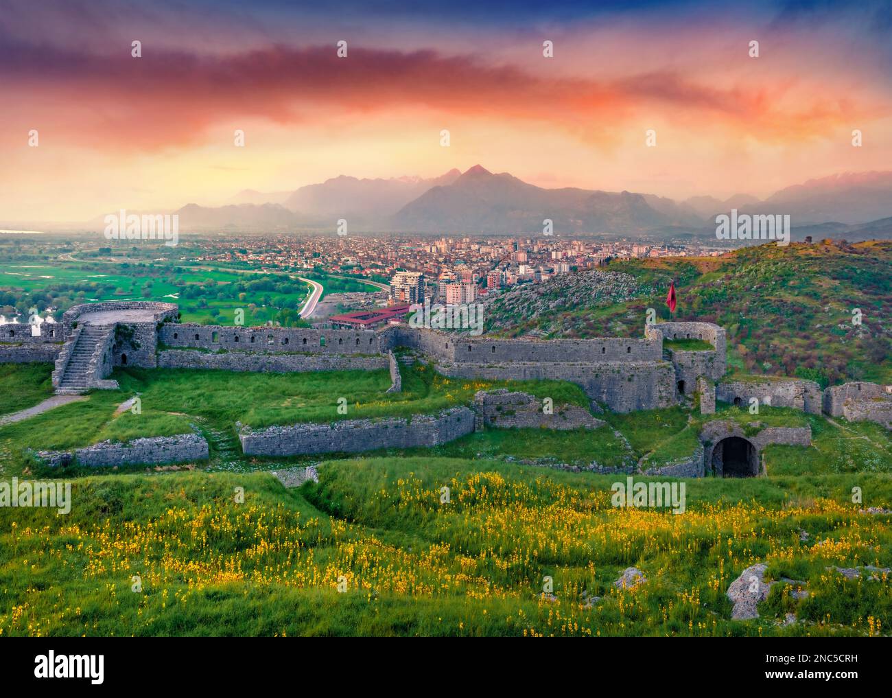 Abend an einem beliebten Touristenziel - Schloss Rozafa. Beeindruckender Sonnenuntergang im Frühling in der Stadt Shkoder mit dem Fluss Buna. Spektakuläre Außenlandschaft von Albanien Stockfoto