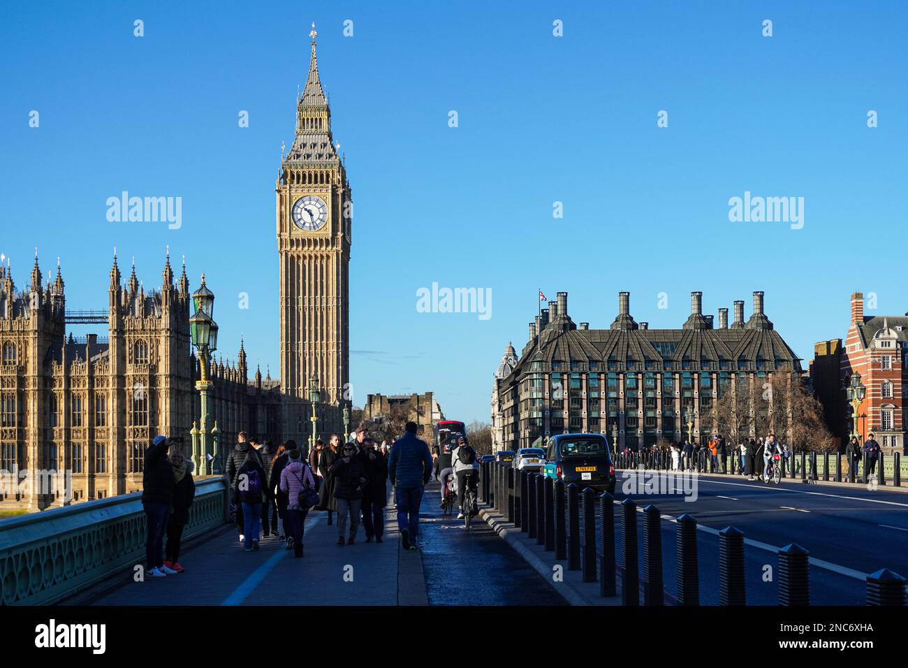 Touristen auf der Westminster Bridge mit dem Big Ben Uhrenturm und dem Palace of Westminster im Hintergrund, London England Großbritannien Stockfoto