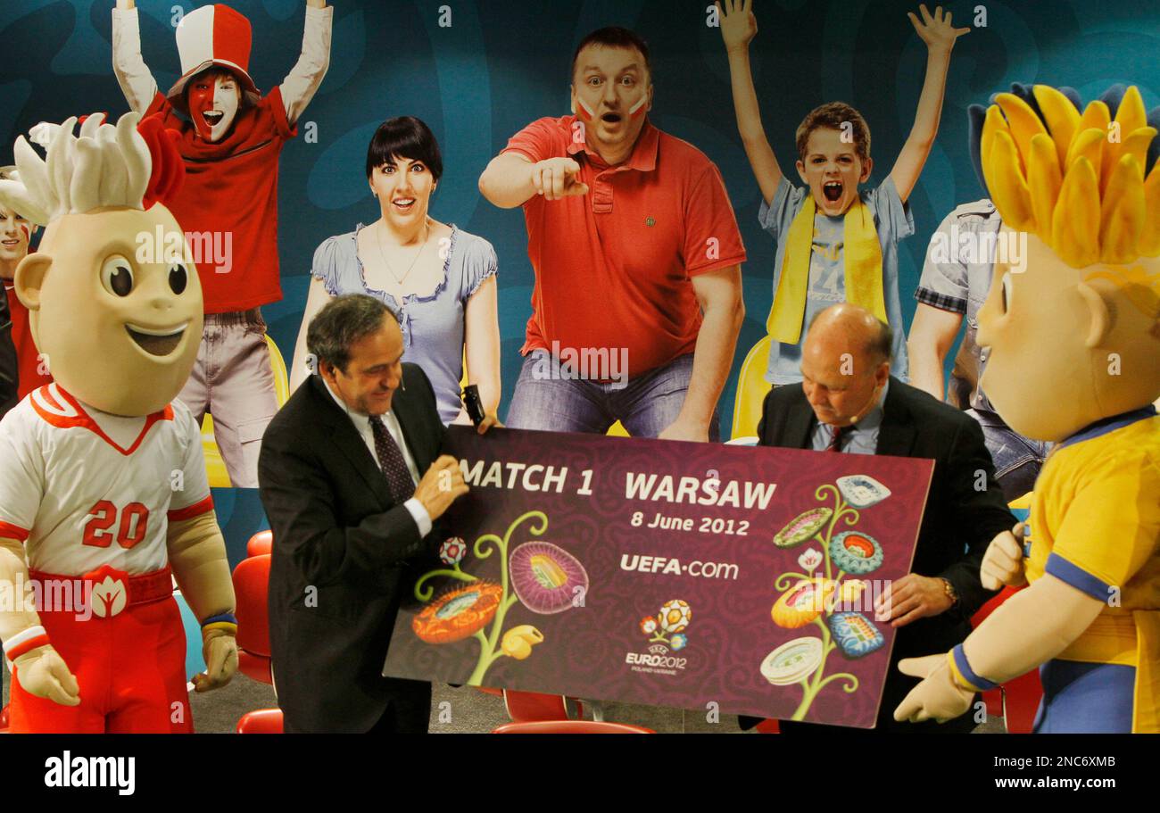 UEFA President Michel Platini, left, and Grzegorz Lato, Polish soccer star gestures next to the Euro 2012 mascots named Slavek, left, and Slavko, as they hold a mock ticket for the first match of the 2012 UEFA Championships in Warsaw, Poland, Tuesday, March 1, 2011. The tickets go on sale on March 1, for the finals of the UEFA European Football Championship, to be held in Poland and Ukraine from June 8 to July 1, 2012.(AP Photo/Czarek Sokolowski) Stockfoto