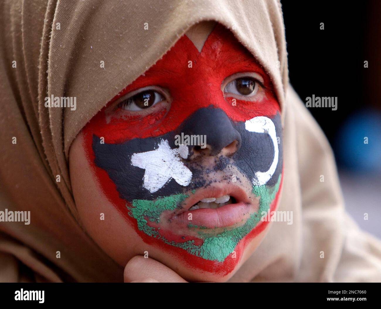 A young anti-Libyan Leader Moammar Gadhafi protester with her face ...