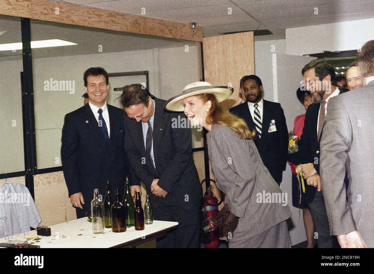 Sarah Ferguson, the Duchess of York, finds special effects rather smashing as she does just that with a bottle to the head of Sean O’Dwyer, her personal secretary as Eric Allard, left, President of All Effects Company, gets a piece or pieces of the action. The fun occurred during the royal couple’s visit to Showscan Film Corp. in Culver City, California, March 1, 1988. (AP Photo/Marilyn Weiss) Stockfoto