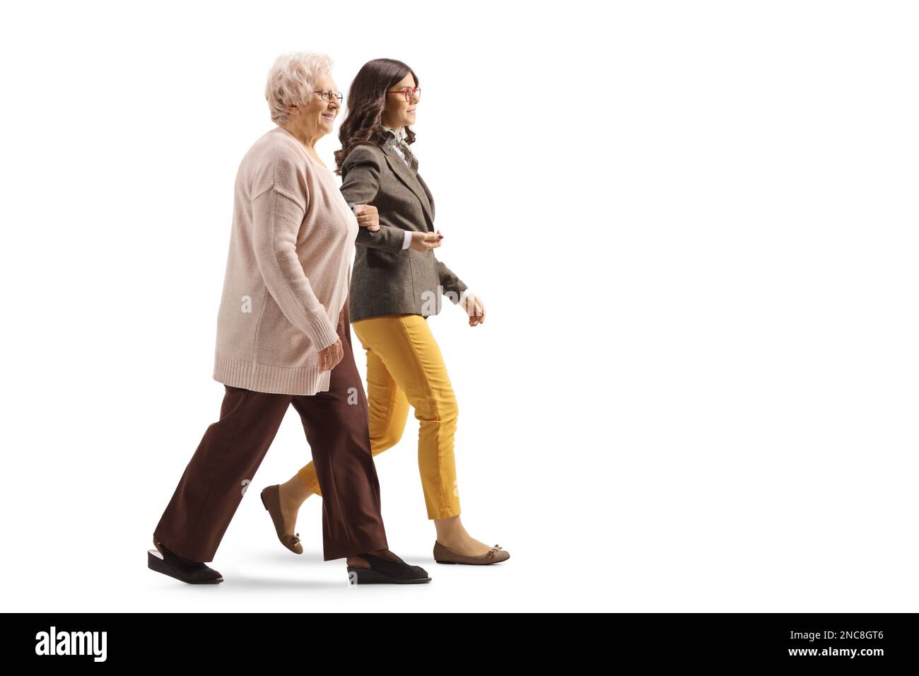 Ältere Frau, die eine junge Frau unter den Armen hält und isoliert auf weißem Hintergrund zusammen geht Stockfoto