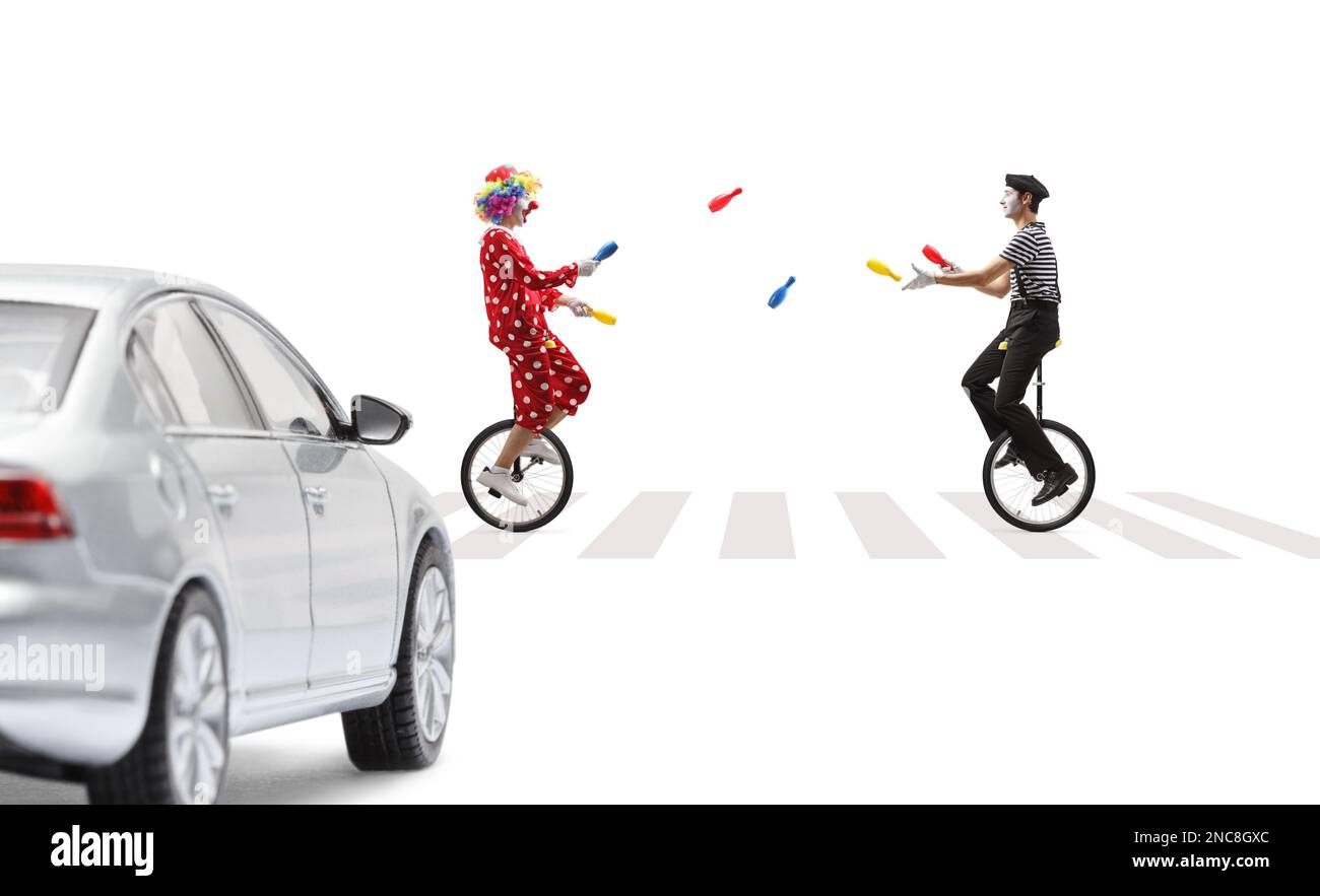 MIME und Clown jonglieren und reiten Einräder auf einer Fußgängerüberquerung isoliert auf weißem Hintergrund Stockfoto
