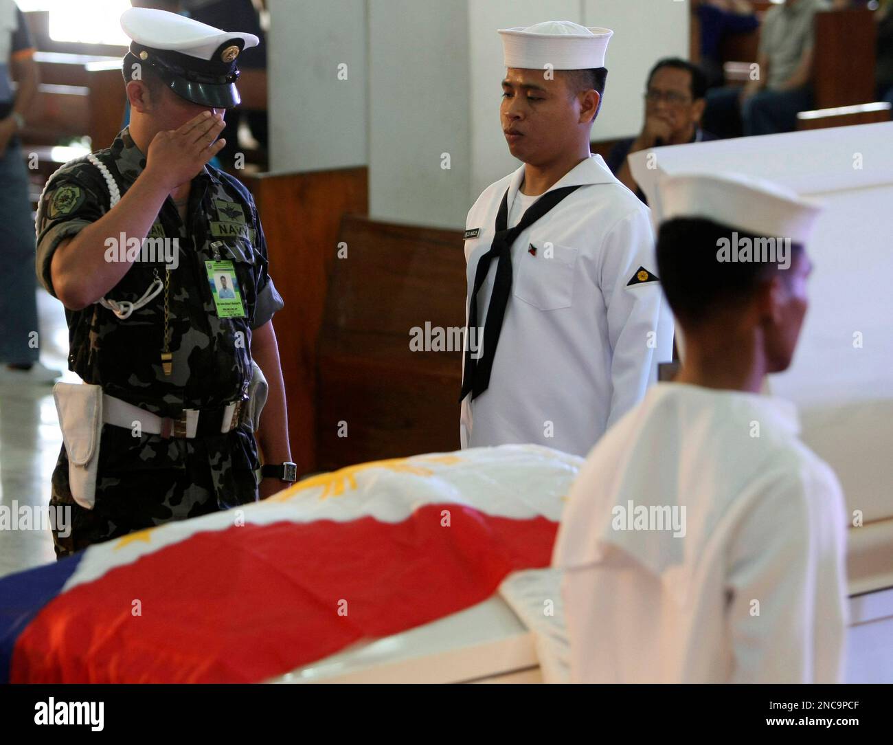 A Philippine military officer salutes to pay his last respects to former Philippine Armed Forces chief Gen. Angelo Reyes during his wake Saturday Feb.12, 2011 at the armed forces headquarters at suburban Quezon city northeast of Manila, Philippines. Reyes, who held various cabinet positions under former President Gloria Macapagal Arroyo, committed suicide by shooting himself at his mother's grave Tuesday, amidst the ongoing Senate and House probe on alleged corruption in the Philippine military. (AP Photo/Bullit Marquez) Stockfoto