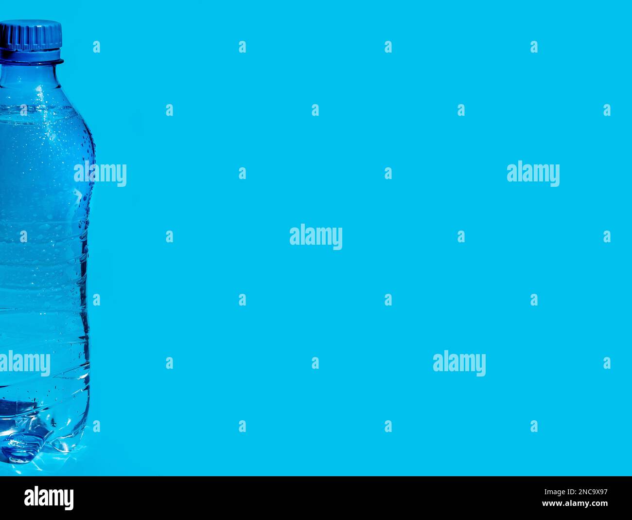 Banner mit feuchter Kunststoffflasche Wasser auf blauem Hintergrund mit Kopierbereich für Text oder Design. Stockfoto