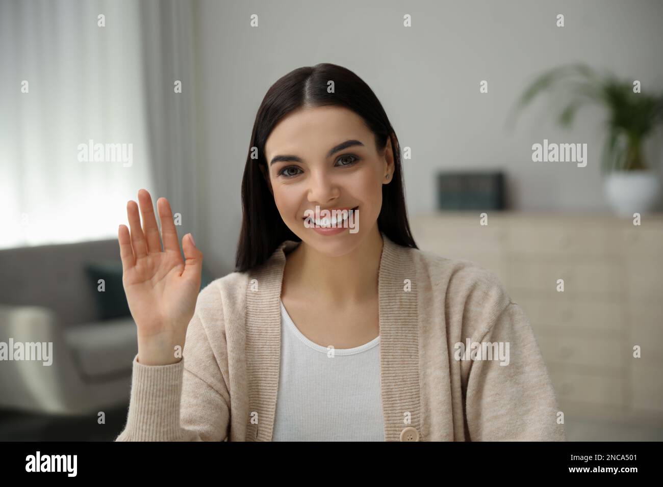 Schöne junge Frau, die ein Webinar im Raum veranstaltet, Kameraansicht Stockfoto