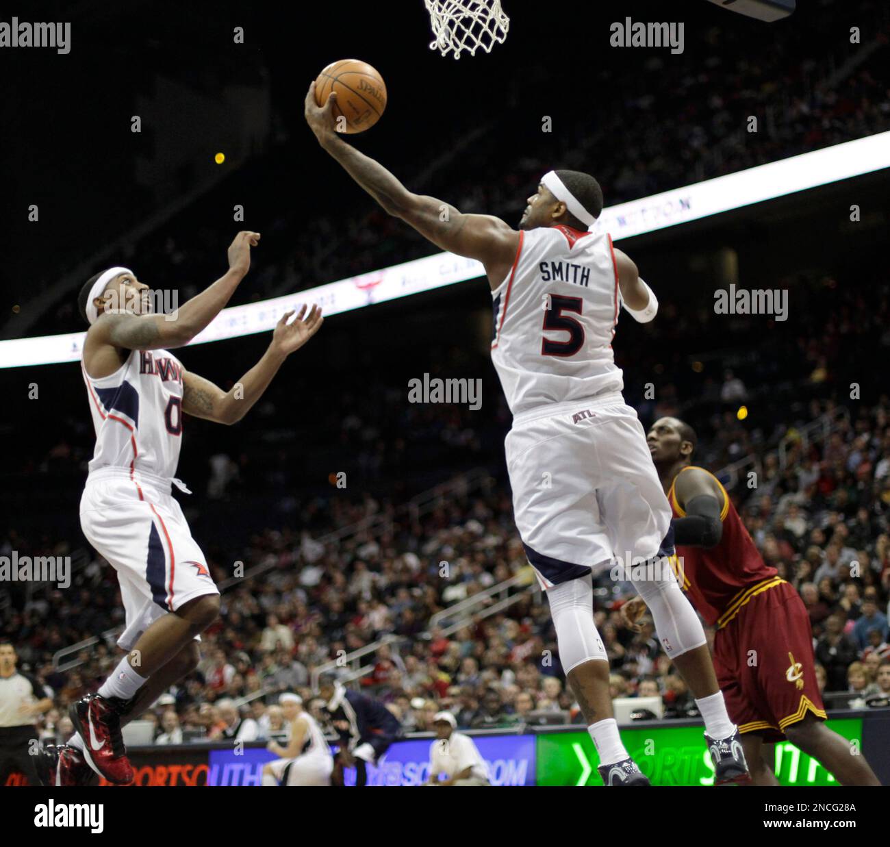 Atlanta Hawks power forward Josh Smith (5) grabs a rebound as teammate Jeff Teague (0) looks on during an NBA basketball game against the Cleveland Cavaliers Wednesday, Dec. 22, 2010, in Atlanta. (AP Photo/David Goldman) Stockfoto