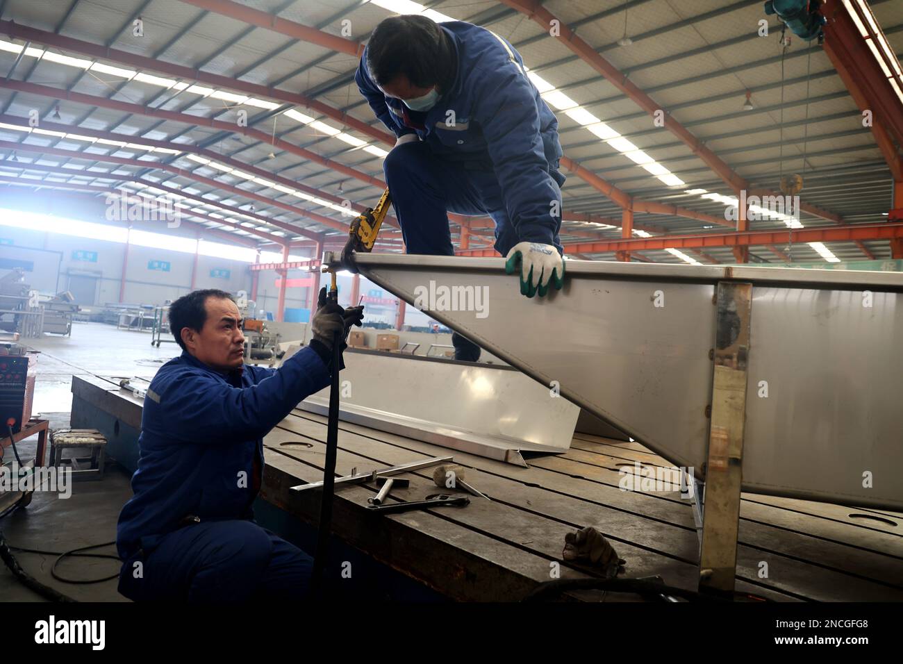 BINZHOU, CHINA – 15. FEBRUAR 2023 – Arbeiter stellen Küchenartikel in einer Werkstatt eines Küchenartikelherstellers in Dianzi, Boxing County, Binzhou City, Stockfoto