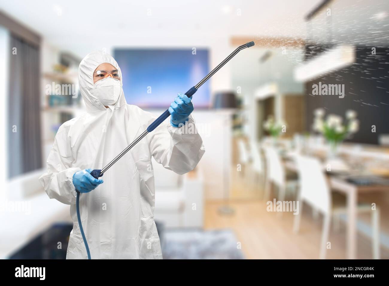 Arbeiter trägt medizinischen Schutzanzug oder weißen Overall Anzug mit Spray desinfizieren Stockfoto