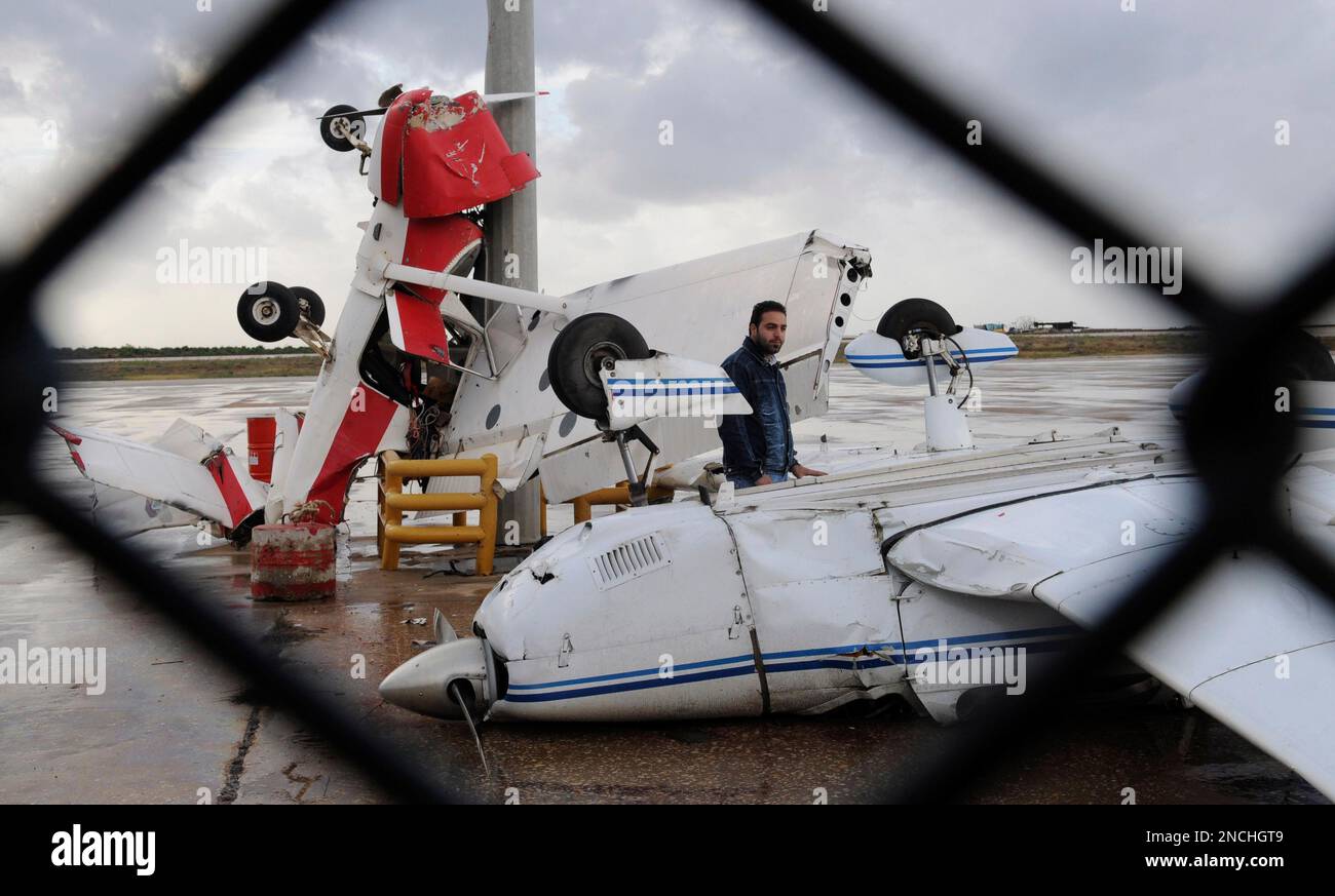 A man checks damaged pilot training planes at the tarmac of Beirut ...
