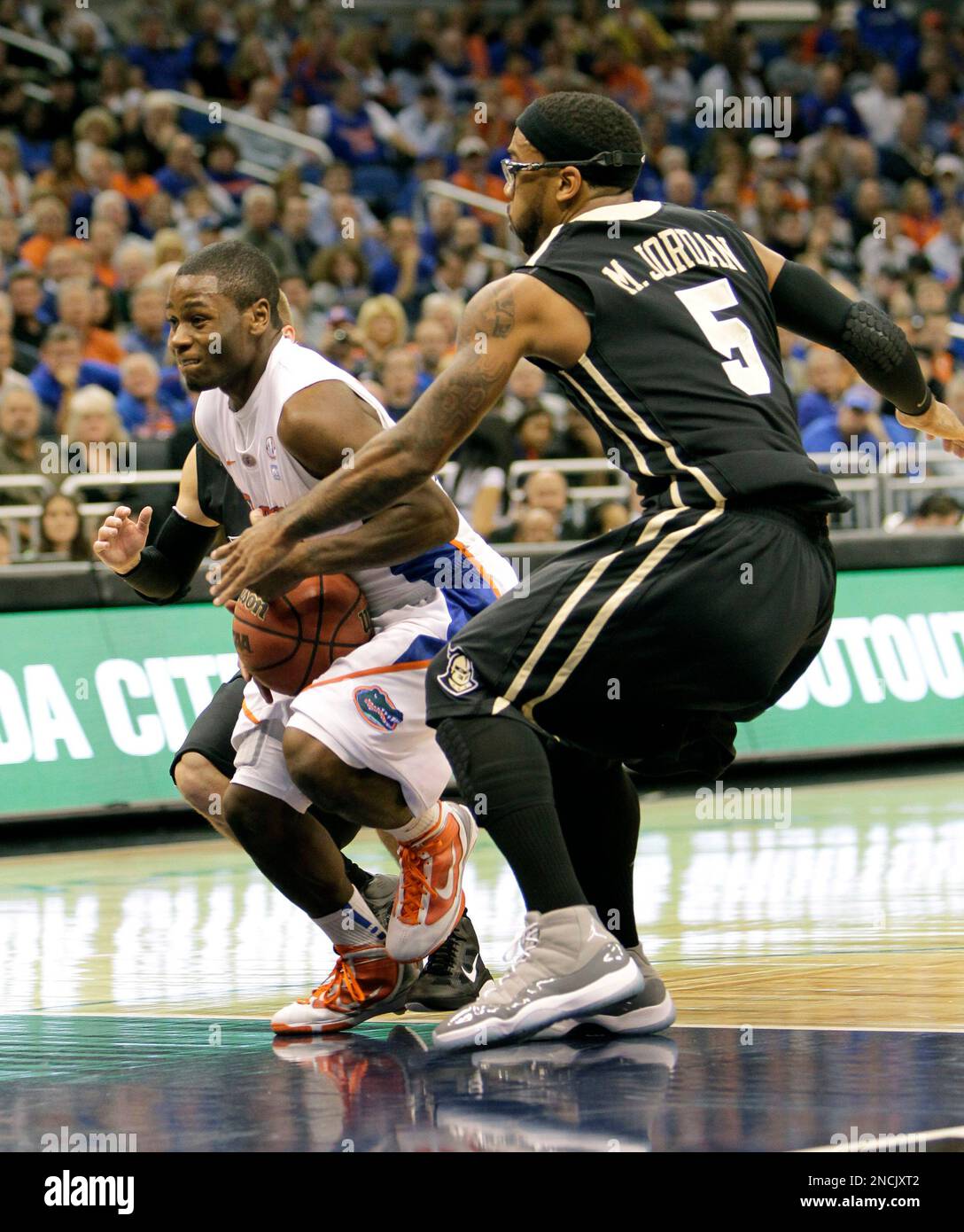 Florida 's Erving Walker, center, drives between Central Florida's A.J
