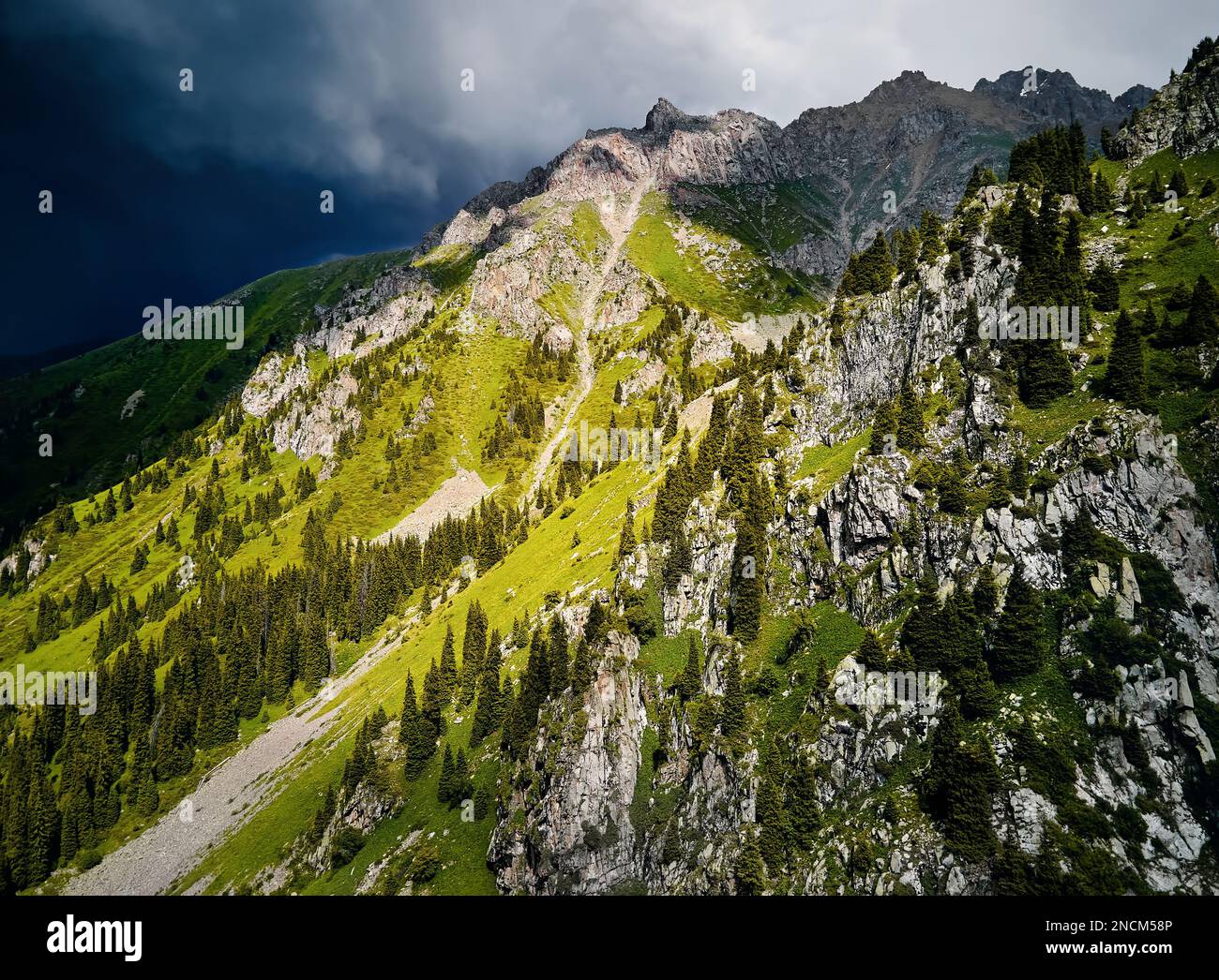 Wunderschöne Landschaft der Berge mit grünen Hügeln bei Sturm, Regen, Wolken in Almaty, Kasachstan. Outdoor- und Wanderkonzept, Luftdrohne Top Shot Stockfoto