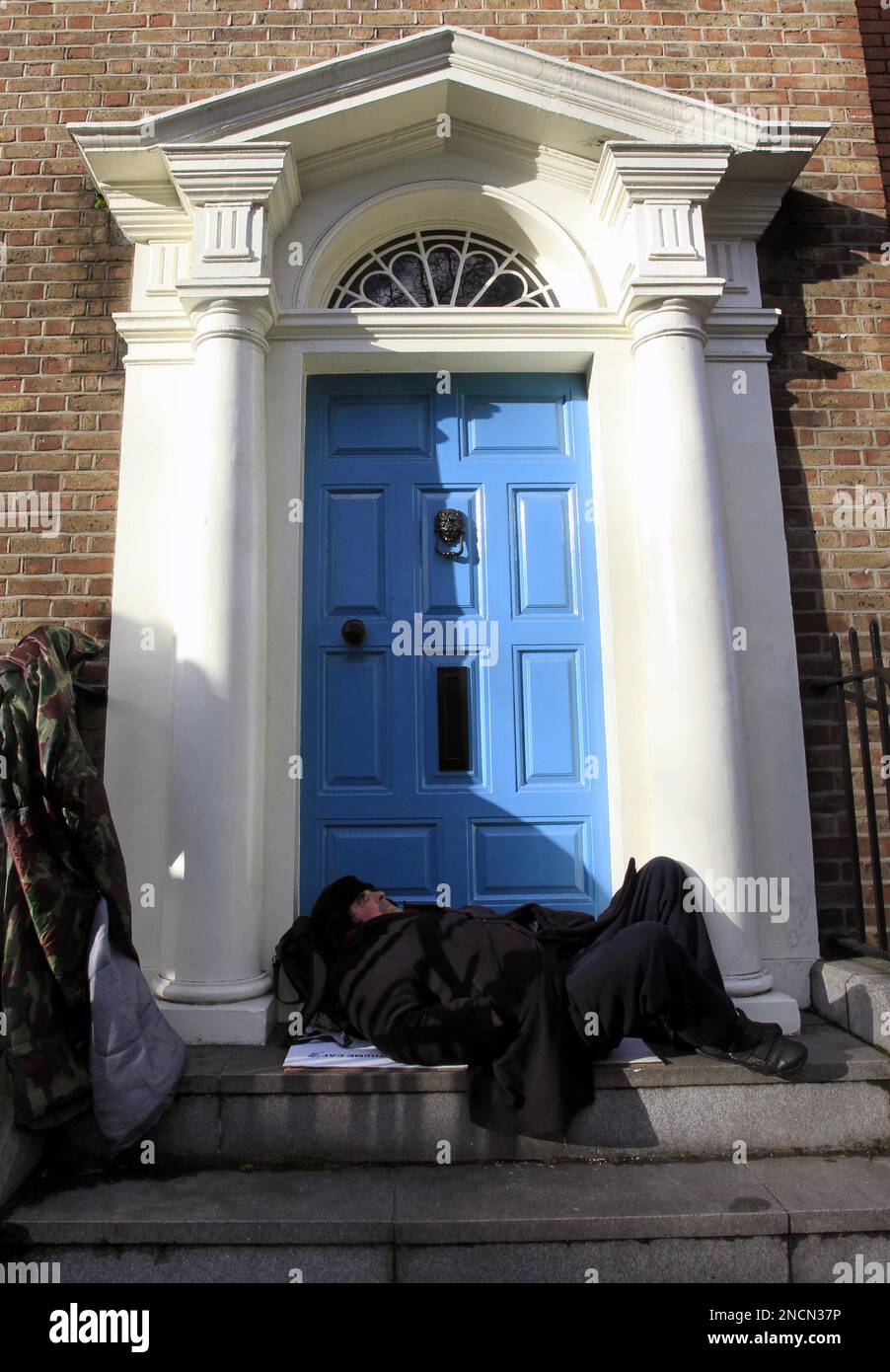 A homeless man sleeps on a doorstep in Dublin, Ireland, Wednesday, Nov. 17, 2010. European officials geared up to travel to Ireland and lift the lid on just how bad the country's banking woes are, as EU finance ministers struggled Wednesday to come up with a rescue plan that will keep bond market turmoil from spreading to Portugal and Spain. (AP Photo/Peter Morrison) Stockfoto