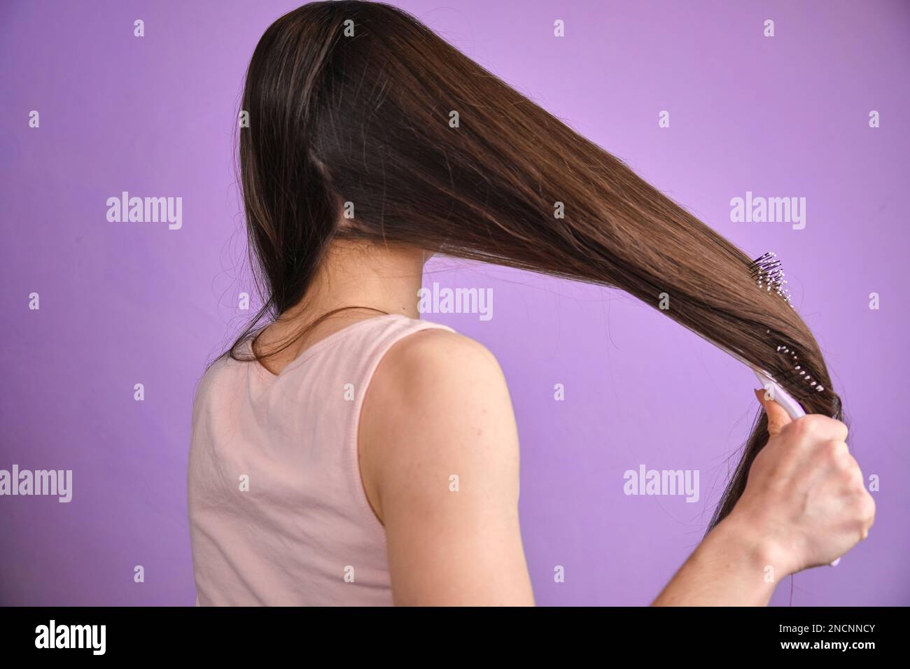 Frau, die ihr nasses, dreckiges Haar nach dem Baden mit Kamm bürstet, Problem mit dünnem Haar. Haarschäden Stockfoto