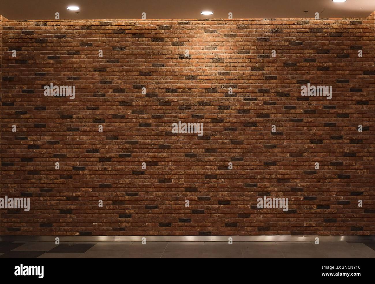 Backsteinwand in roter Farbe, Hintergrundbeleuchtung mit breiter Panoramatextur von oben Stockfoto