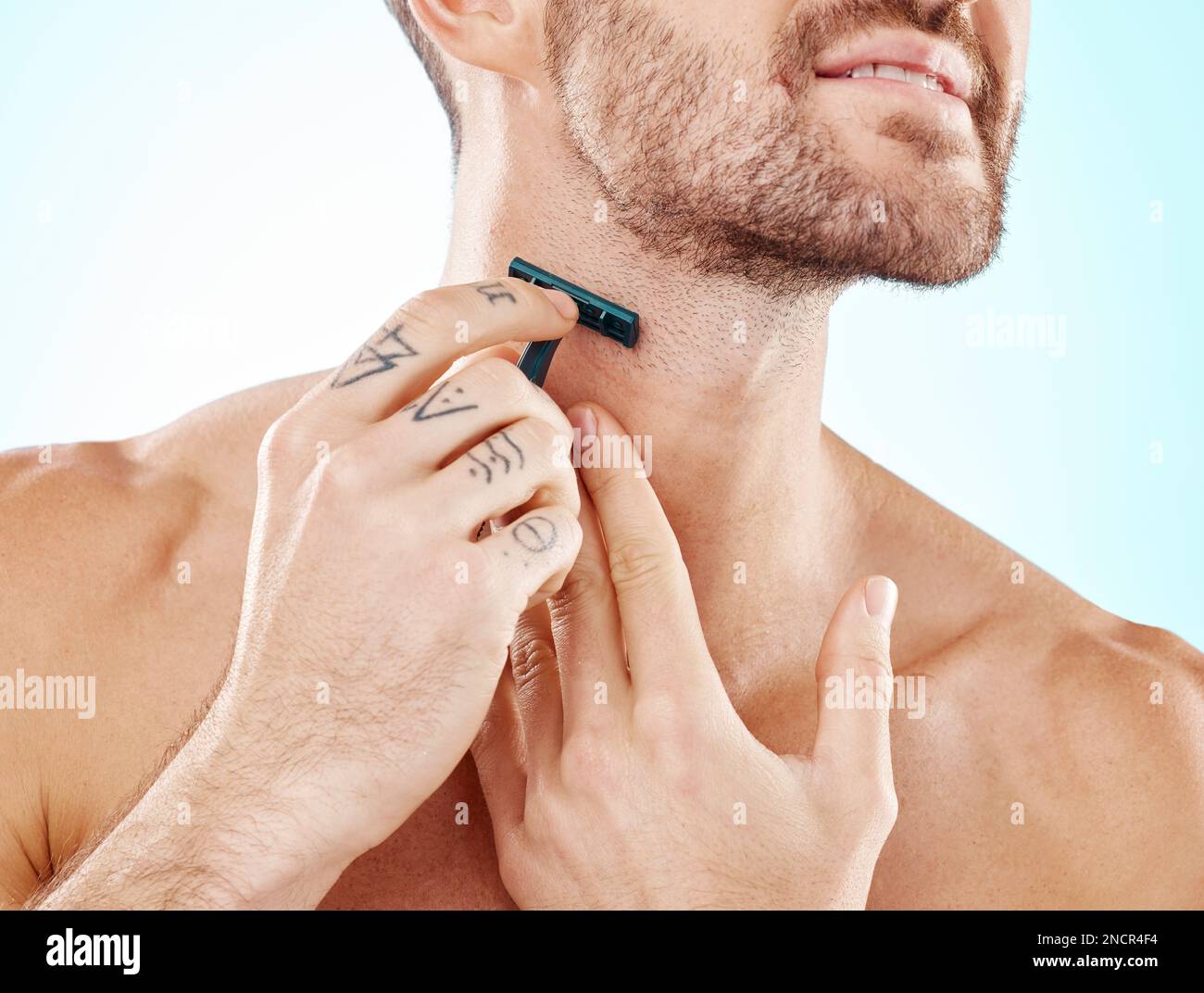 Hände, Rasur und Bart mit einem Mann, der im Studio auf blauem Hintergrund für Hautpflege oder Hygiene pflegt. Rasieren, Tätowieren und Nacken mit einem Mann im Stockfoto