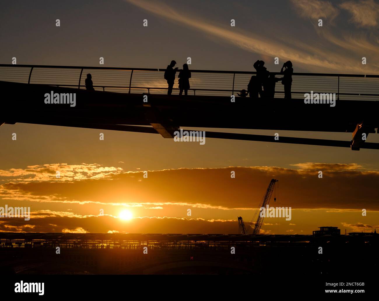 Silhouette der Menschen auf der Millennium Bridge London, wenn die Sonne hinter sich geht. Stockfoto