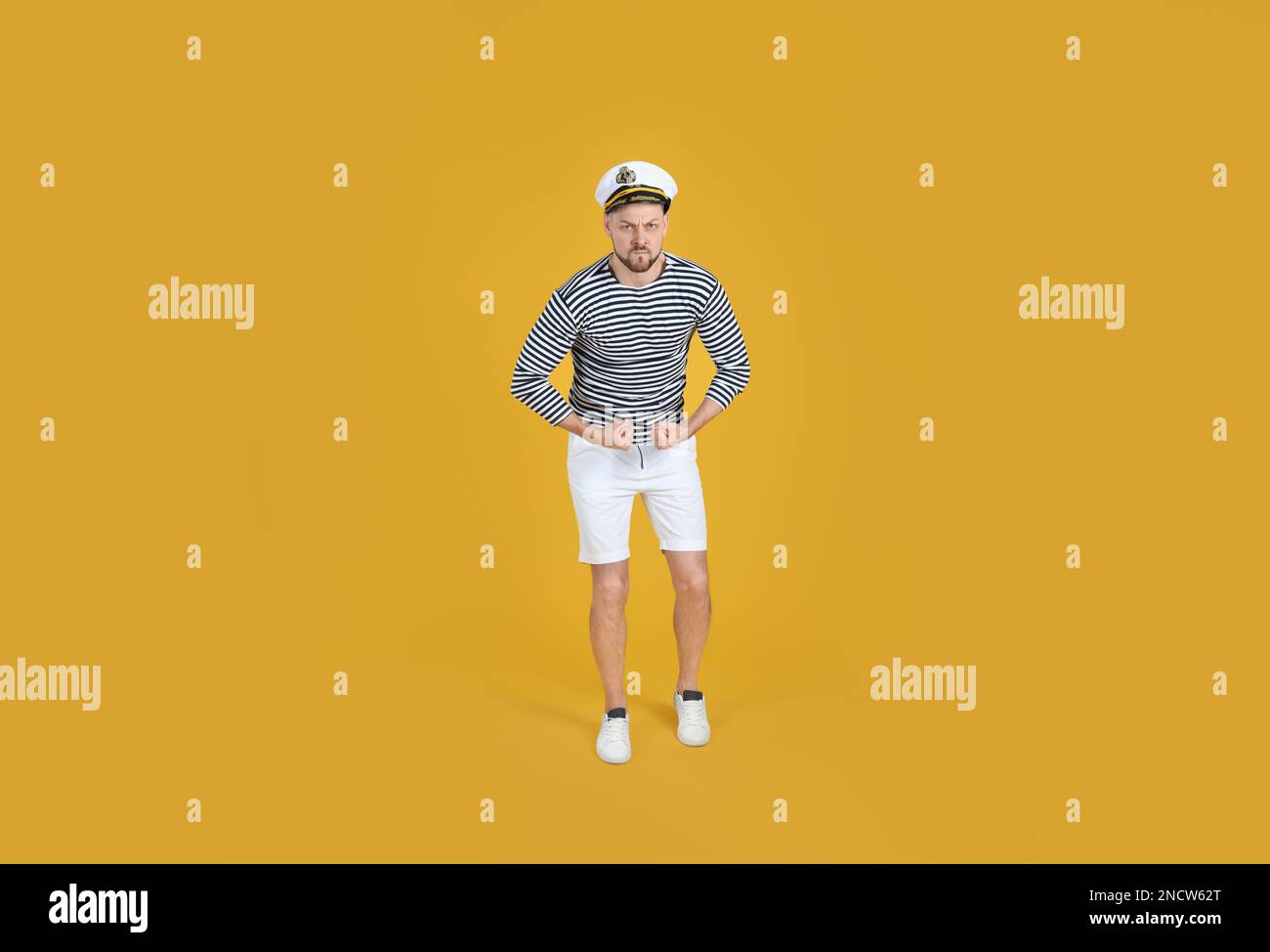 Ein echter Seemann zeigt Kraft auf gelbem Hintergrund Stockfoto