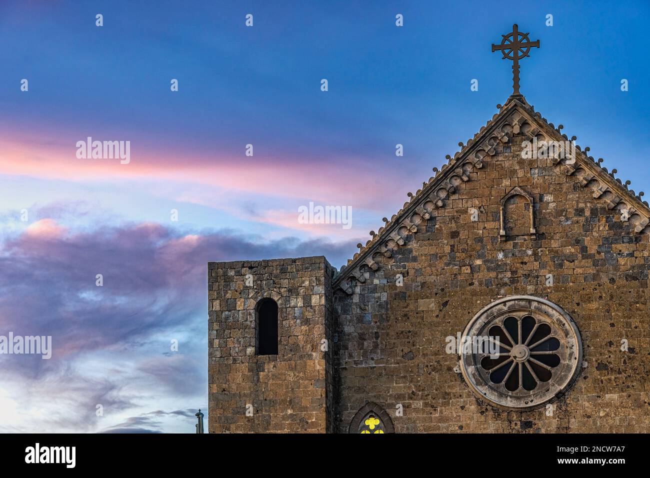 Fassade der Kirche San Salvatore bei Sonnenuntergang. Es befindet sich vor dem Rocca Monaldeschi, ist im gotischen Stil und hat zwei Türme an den Seiten. Stockfoto