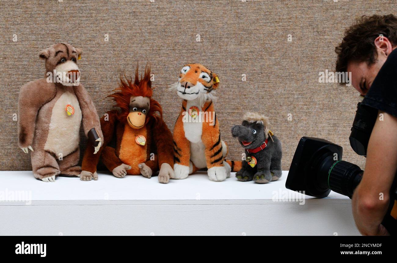 A cameraman films four Steiff post-war Walt Disney Jungle Book characters, Baloo bear, King Louie orangutan, Shere Khan tiger, and Baby Hathi elephant soft toys on display at an auction house in London, Friday, Oct. 8, 2010. The character soft toys are to be auctioned in a 'Private Collection of Steiff Teddy Bears and Soft Toys' sale on Oct. 13 with an estimated price of 700 to 1,000 pounds ($1,111 to 1,587 or 798 to 1,141 euro). (AP Photo/Sang Tan) Stockfoto