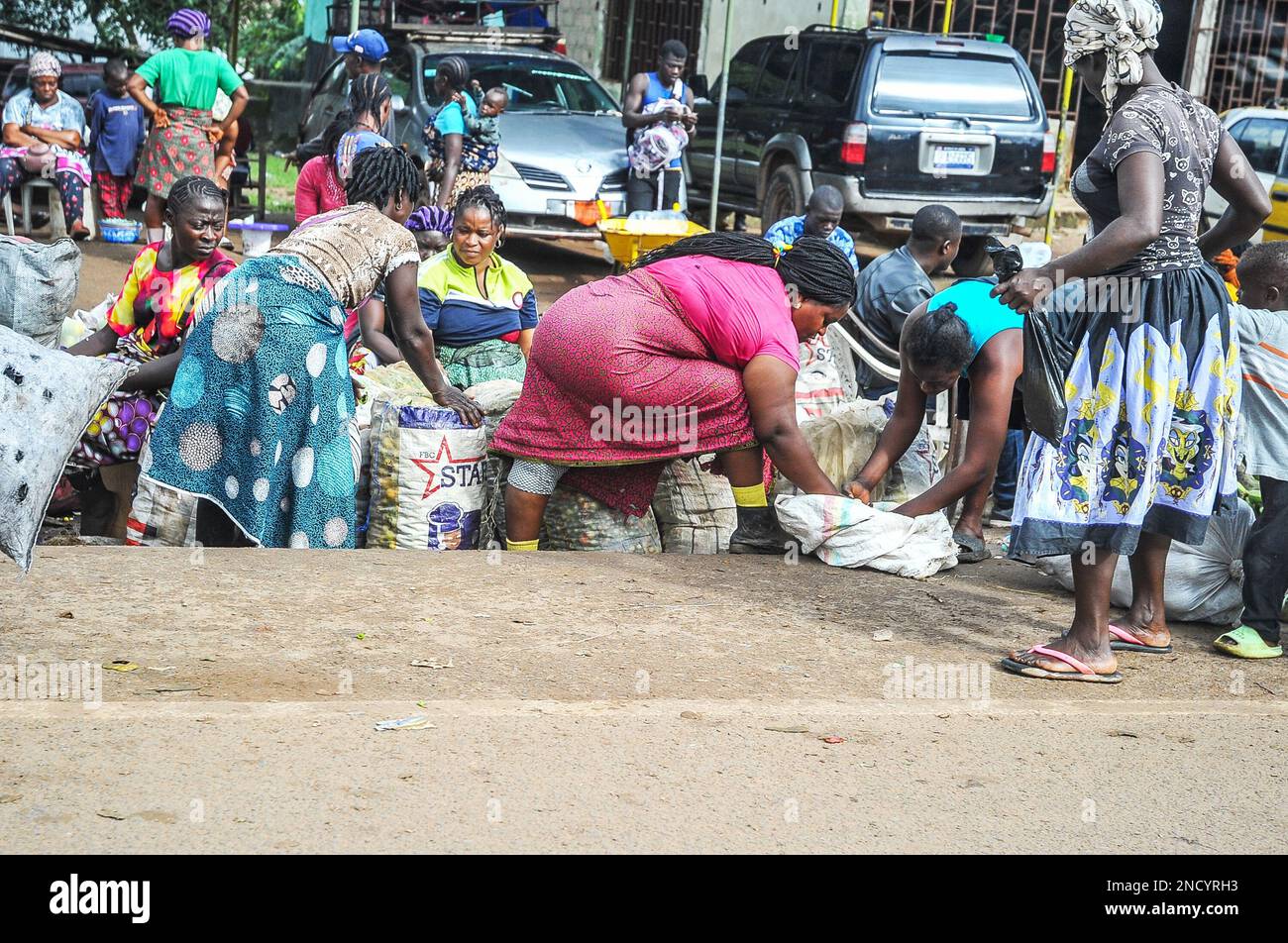 Einkaufen und Verkaufen auf dem geschäftigen Monrovia - Gbarnga Highway. Der Markt ist sehr geschäftig, und die Anbieter nehmen einen Teil der Straße ein, was zu starken Staus führt. Liberia. Stockfoto