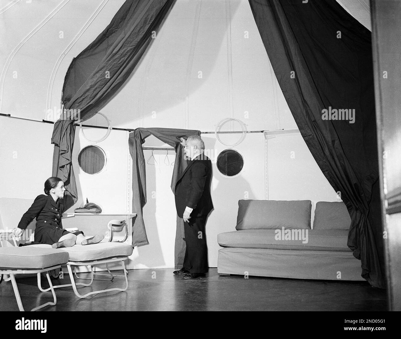 R. Buckminster Fuller, inventor of the Dymaxion Deployment Unit, which consists of three units and can be used as a bomb shelter or for living quarters is shown relaxing in the shelter in New York on October 9, 1941. This unit is part of exhibit in the sculpture garden of the Museum of Modern Art. (AP Photo/Tom Fitzsimmons) Stockfoto