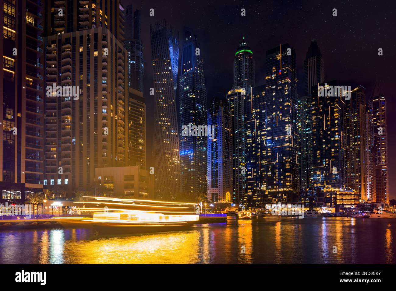 Dubai Marina bei Nacht, beleuchtete Wolkenkratzer und Kanalboote. VAE Stockfoto