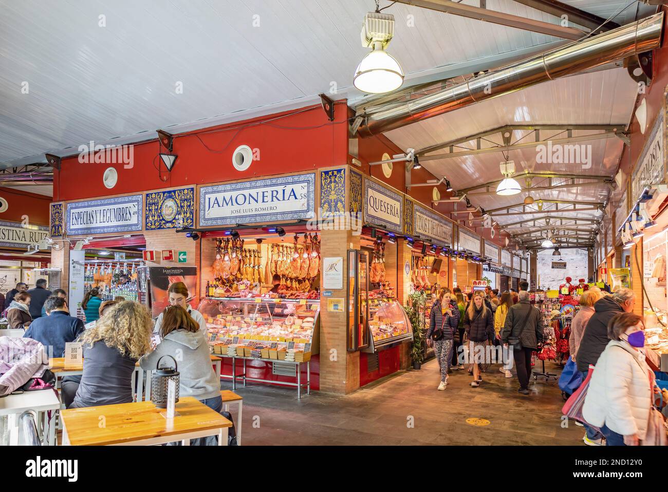 Sevilla, Spanien - 4. Januar 2023: Das Innere des Mercado de Triana, ein malerischer überdachter Markt mit vielen Verkaufsständen, die landwirtschaftliche Produkte und Fleisch verkaufen Stockfoto