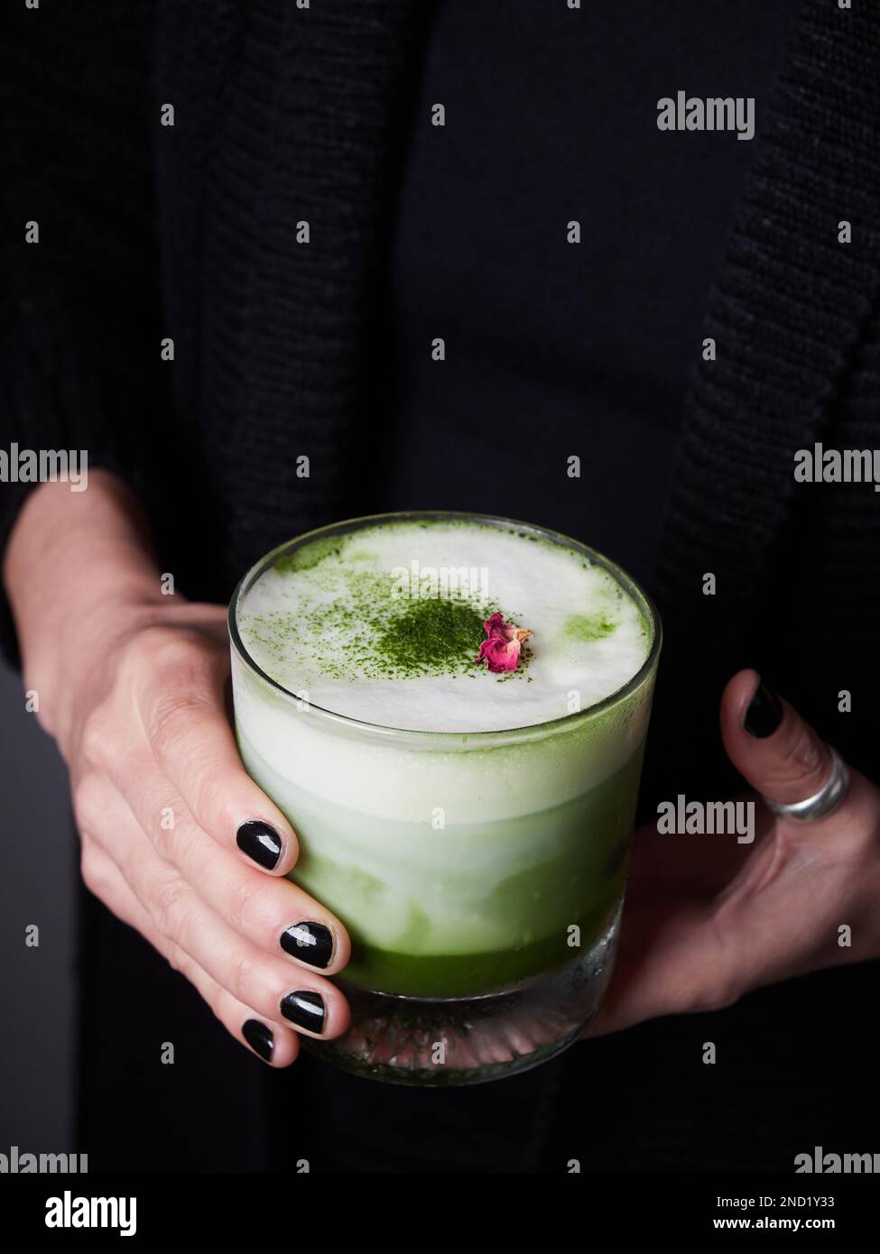 Unbekannte Frau mit Gläsern grüner Matcha-Cocktails mit Milch Stockfoto