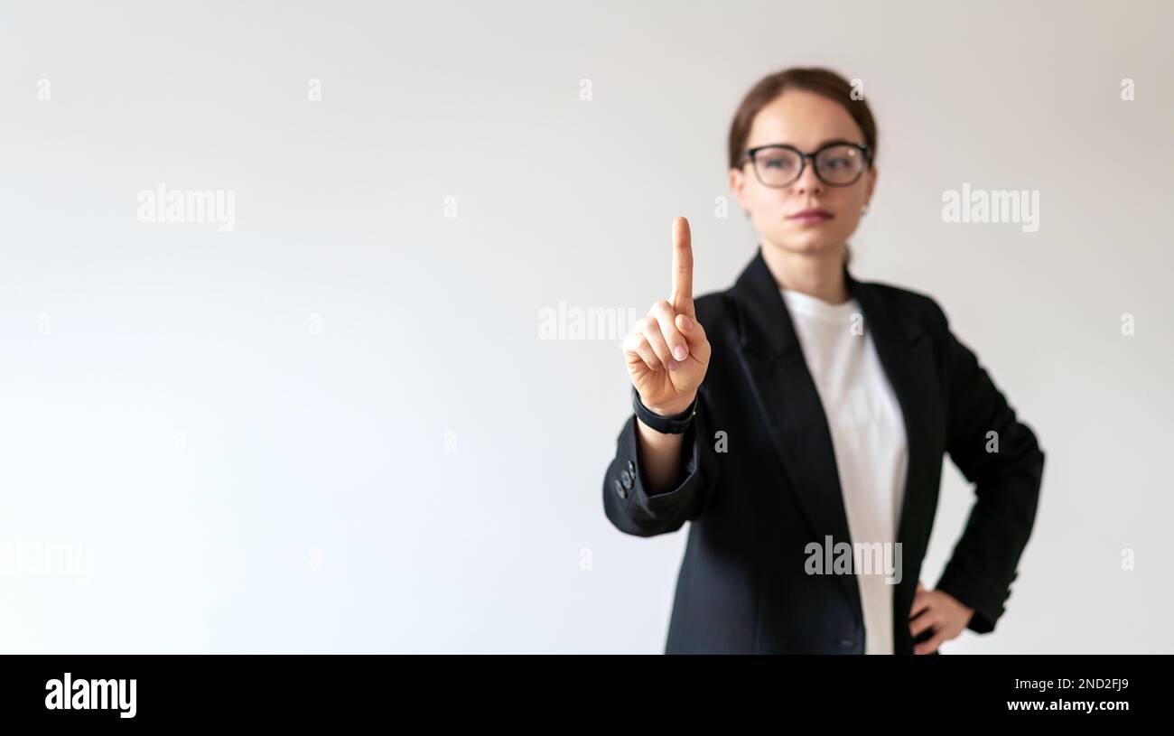 Frau in Brille, die einen virtuellen transparenten Bildschirm mit dem Finger berührt. Stockfoto