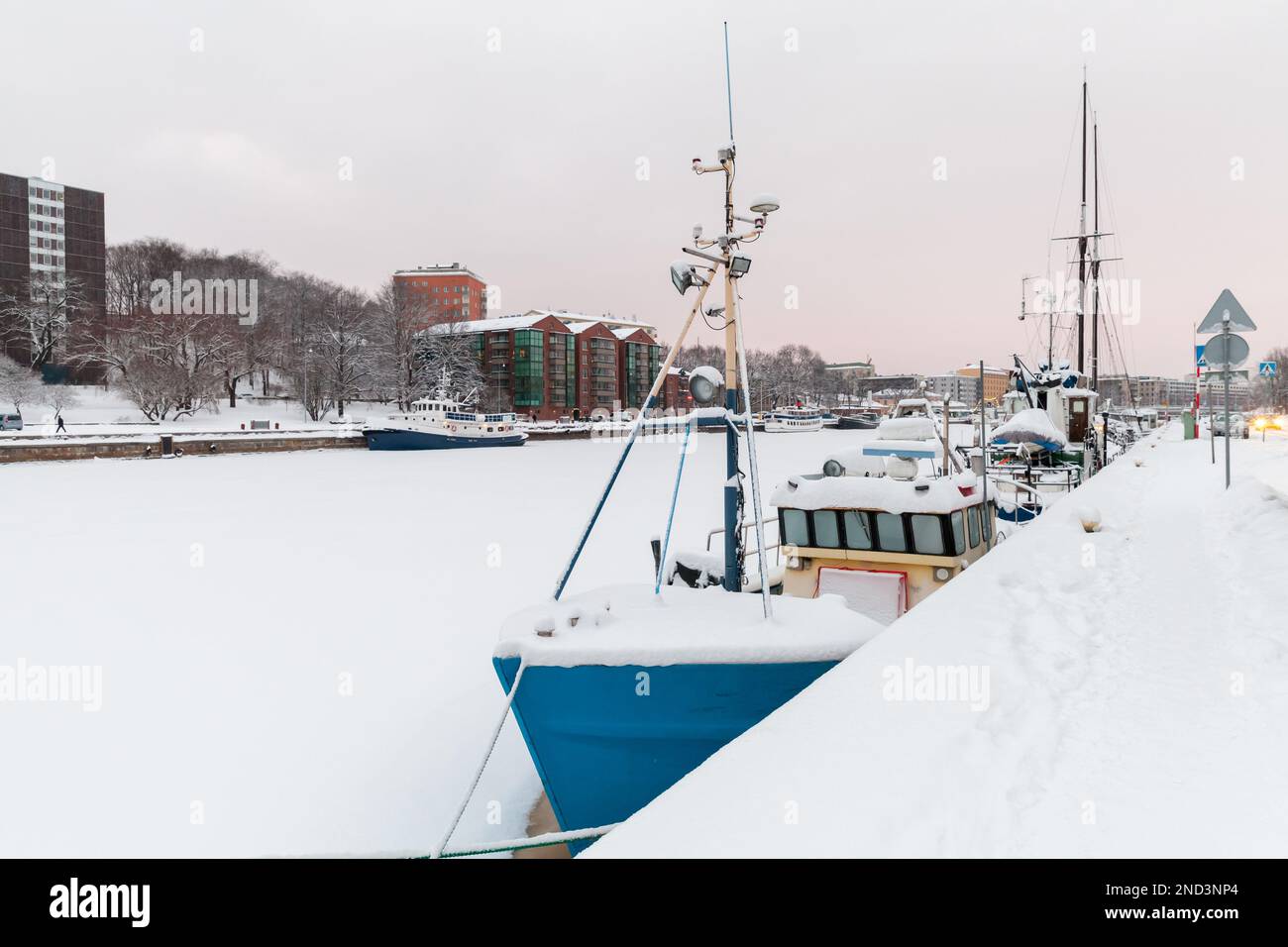 Kleine Boote liegen an der Küste des Flusses Aura an einem Wintertag vor. Turku, Finnland Stockfoto