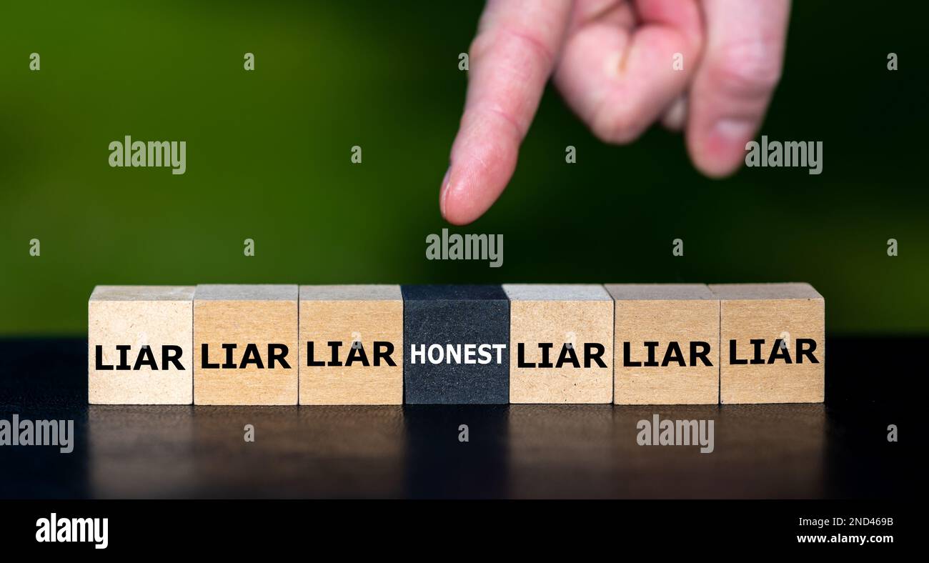 Hand wählt den Würfel mit dem Wort „ehrlich“ statt Würfel mit dem Wort „Lügner“ aus. Stockfoto