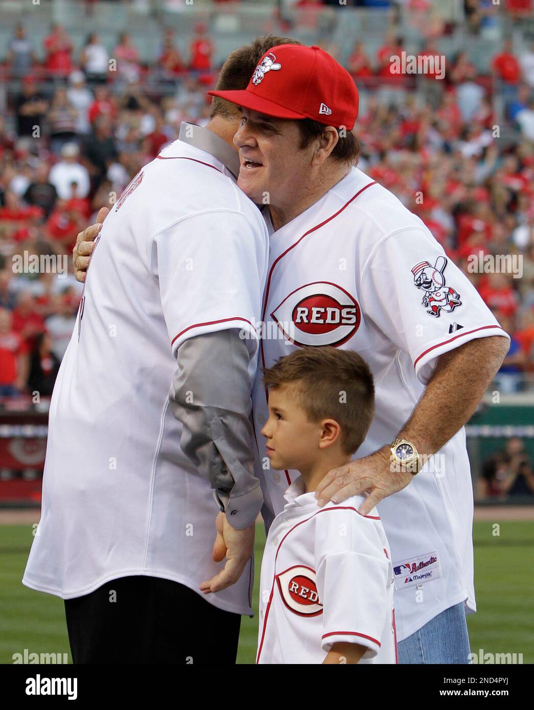 Former Cincinnati Reds great Pete Rose stands hugs his son, Pete Rose Jr., and grandson Pete Rose III, during ceremonies celebrating the 25th anniversary of Rose breaking Ty Cobb's hit record prior to a baseball game between the Reds and Pittsburgh Pirates, Saturday, Sept. 11, 2010, in Cincinnati. (AP Photo/Al Behrman) Stockfoto