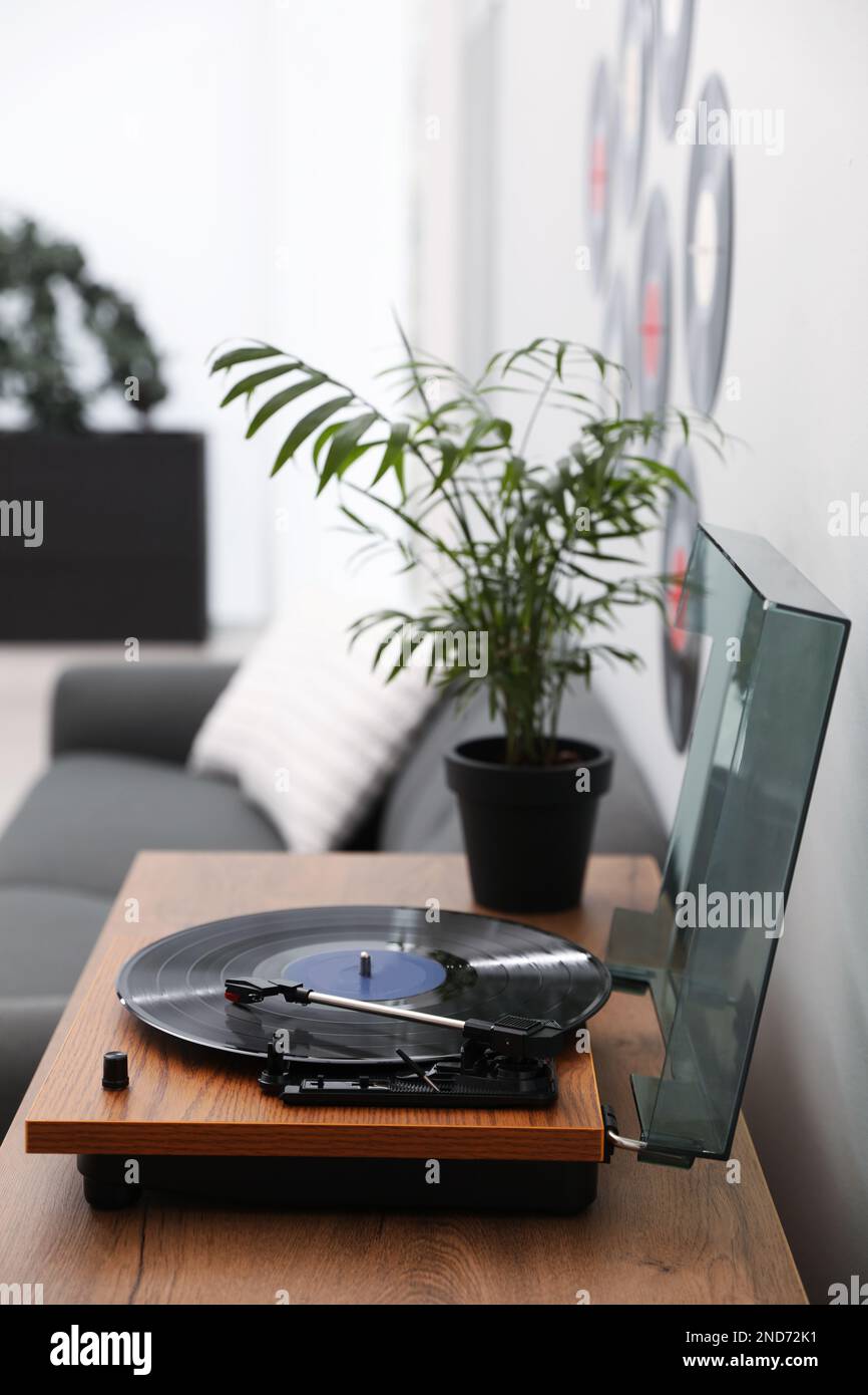 Eleganter Plattenspieler mit Vinylscheibe im Wohnzimmer Stockfoto