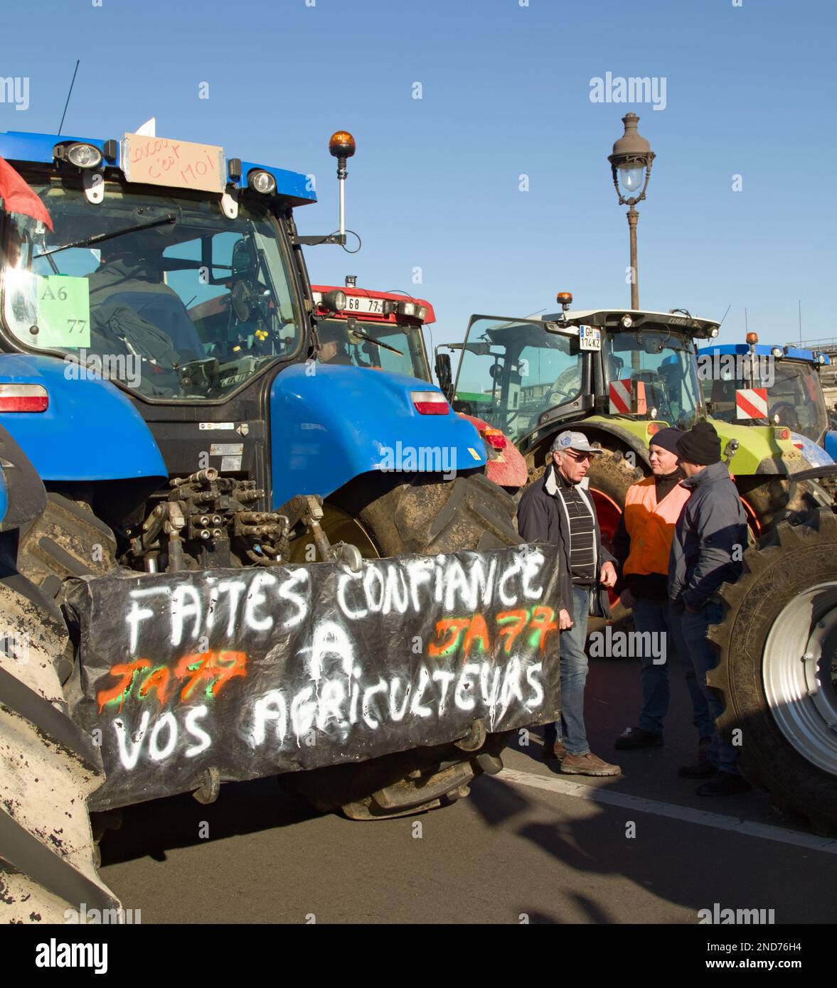 Französische Bauern stehen neben Einer Reihe von Traktoren mit Bannern, die gegen die französische Regierung protestieren, Paris, 8. Februar 2023 Stockfoto