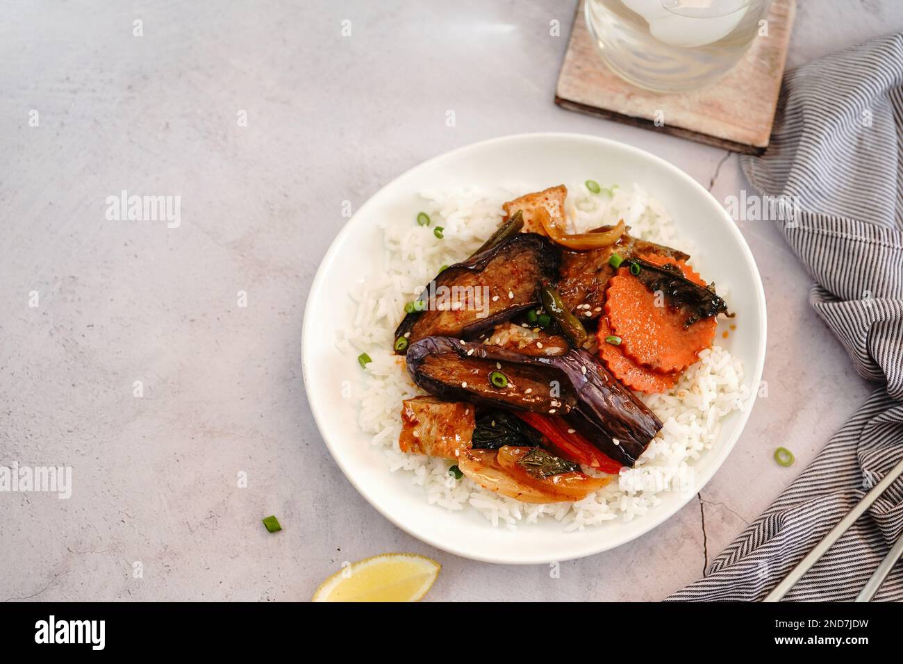 Gebratene thailändische Aubergine mit Gemüse in süßer Sauce, serviert mit Jasminreis Stockfoto