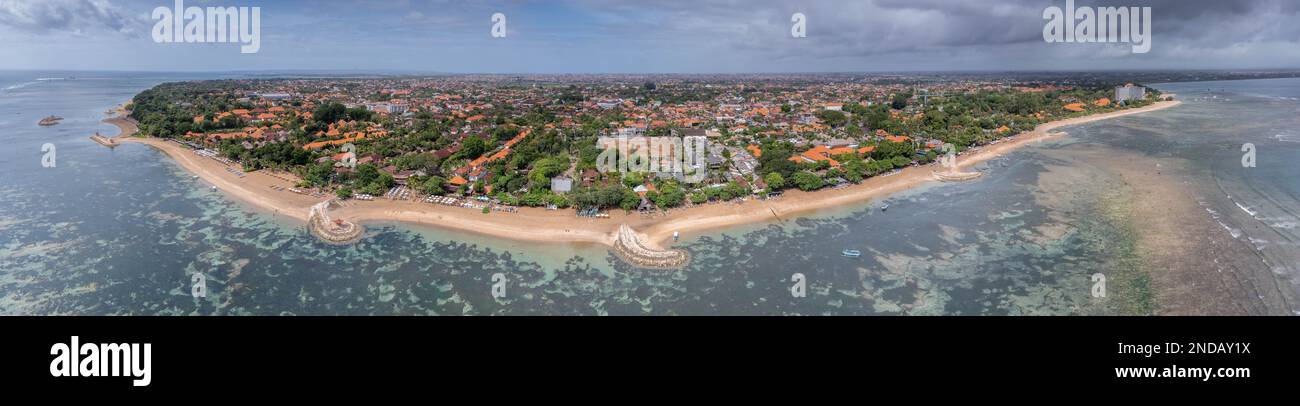 Malerischer Panoramablick vom ganzen Sanur Strand von Süden nach Norden, sehr breite, sehr flache Küste, dunkle, schwere Wolken vor Regen, Bali, Indonesien Stockfoto