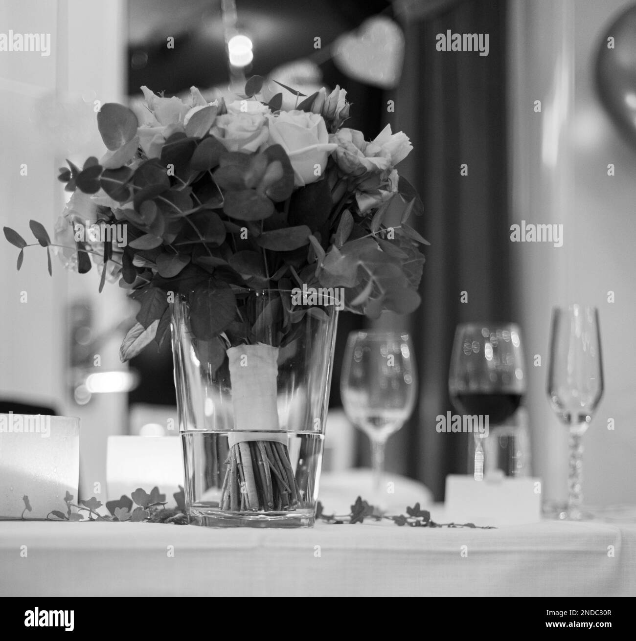 Schwarzweißfoto eines Brautstraußes in einer Vase auf einem Tisch Stockfoto
