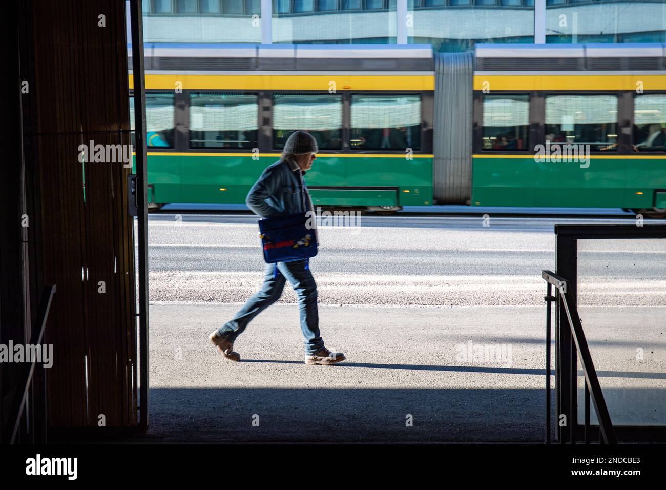 Unscharfe Bewegung eines Mannes, der Siltasaarenkatu im Hakaniemi-Bezirk Helsinki, Finnland, entlang geht Stockfoto