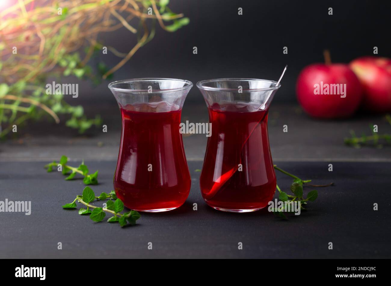 Türkischer Früchtetee in Glasbecher auf schwarzem Hintergrund. Sommersaison. Konzept von Teezeit und Sommer. Weichzeichnerfokus Stockfoto