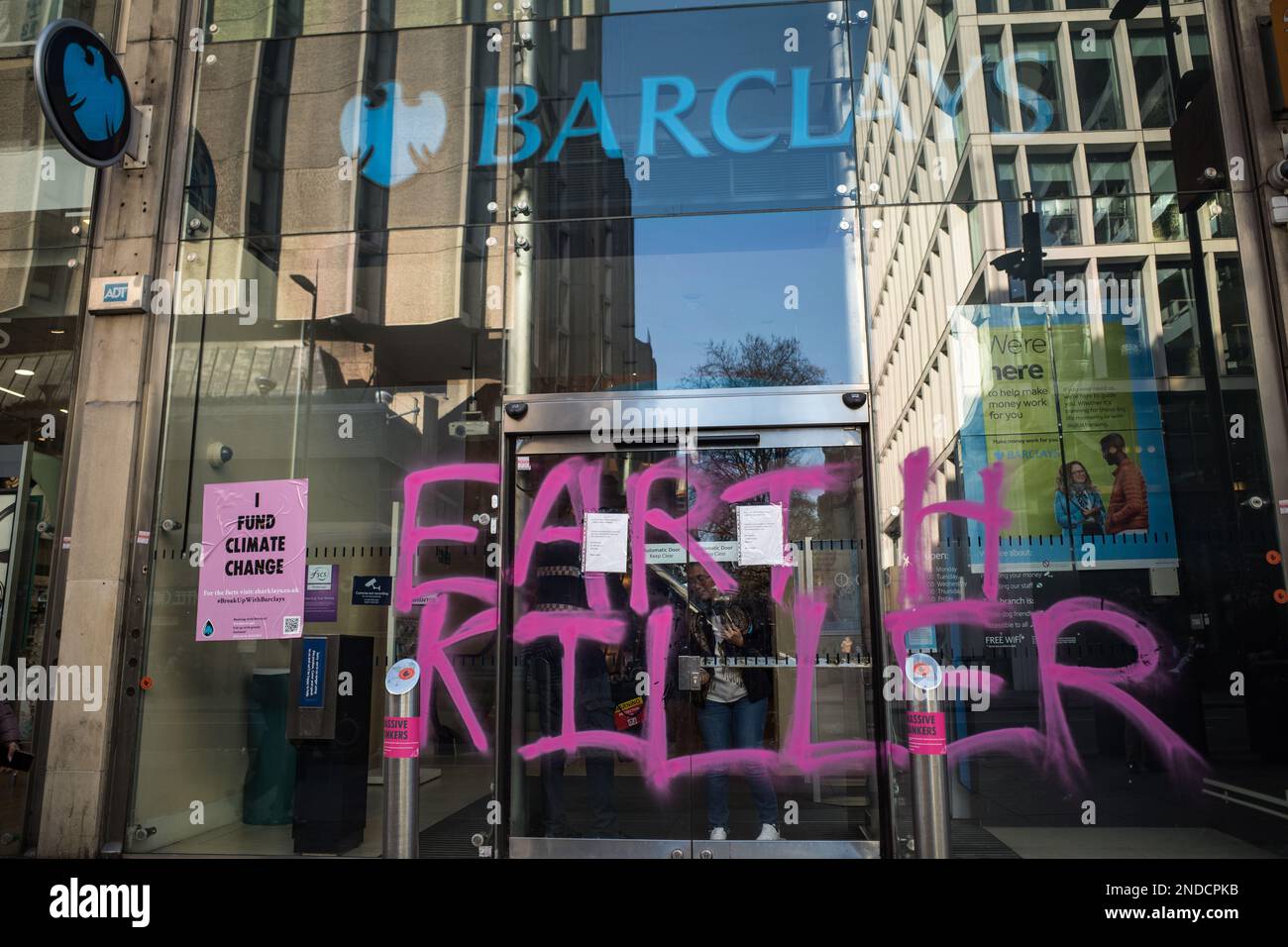 Klimaschutzaktivisten malen 'Earth Killer' Graffiti auf Barclays Bank, Tottenham Court Road Zweigstelle, London, Februar 2023. Aussterbende Rebellion. Stockfoto