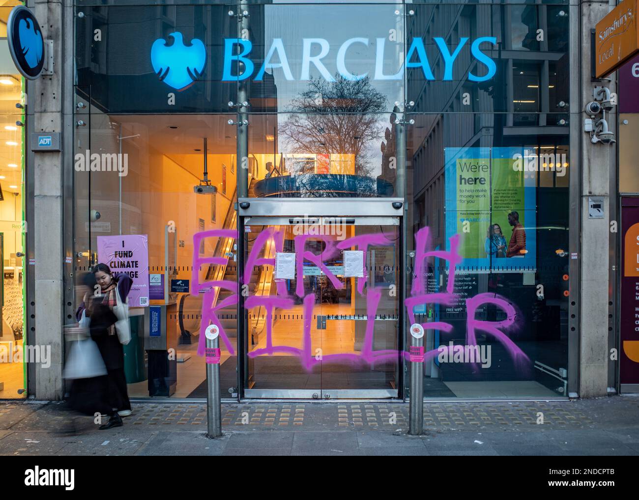 Klimaschutzaktivisten malen 'Earth Killer' Graffiti auf Barclays Bank, Tottenham Court Road Zweigstelle, London, Februar 2023. Aussterbende Rebellion. Stockfoto